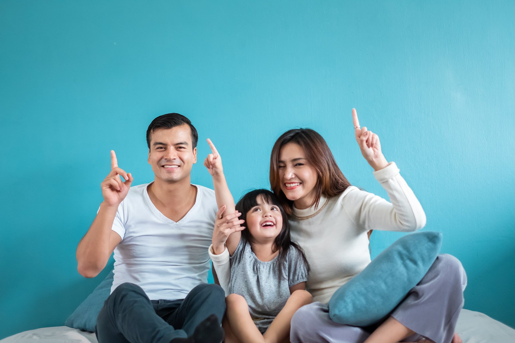 Portrait happy Asian family over blue background